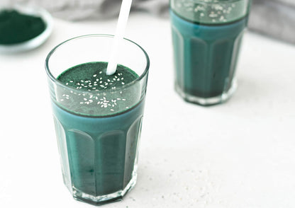 Scoop of green algae powder showing fine texture