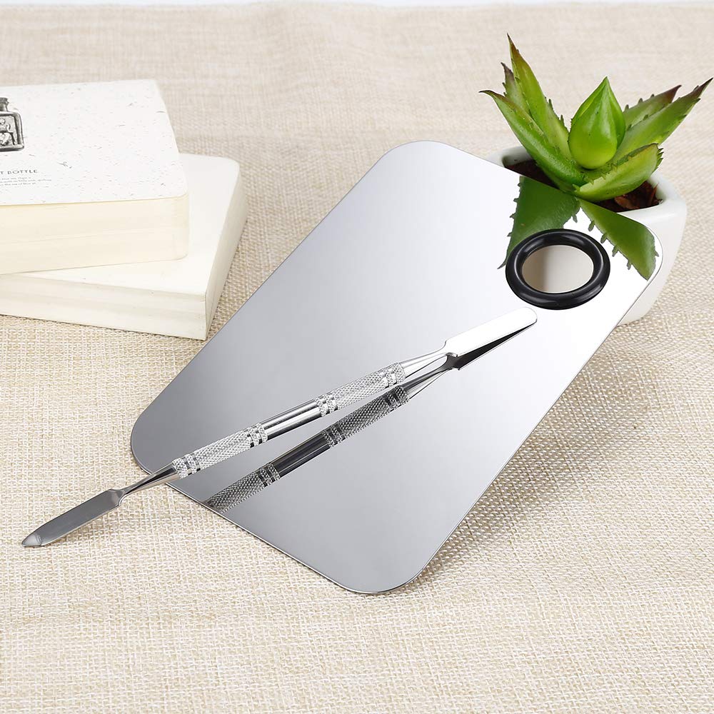 Dual-ended mixing spatula resting beside the stainless steel tray