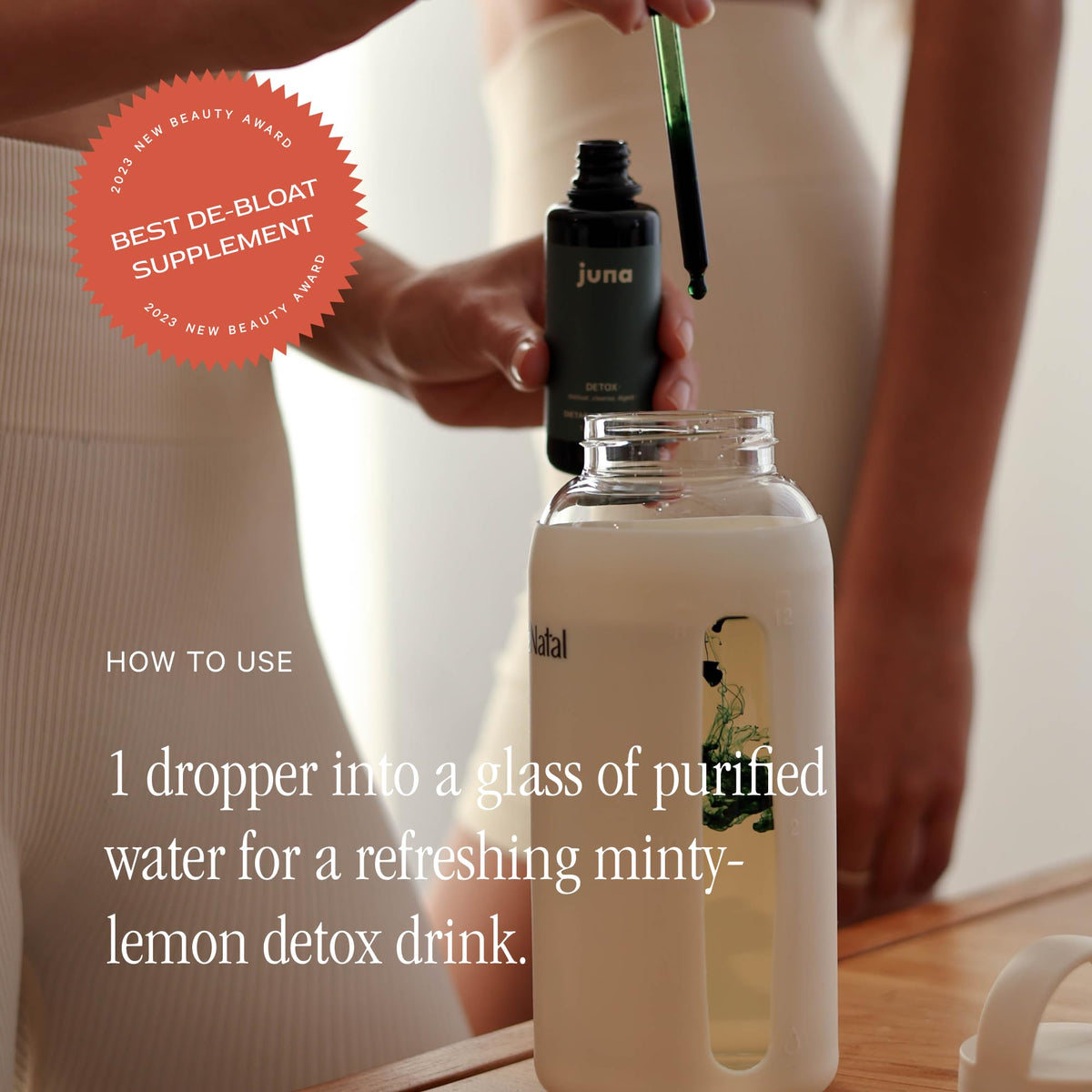 Juna chlorophyll drops bottle next to a glass of lemon mint infused refreshing water