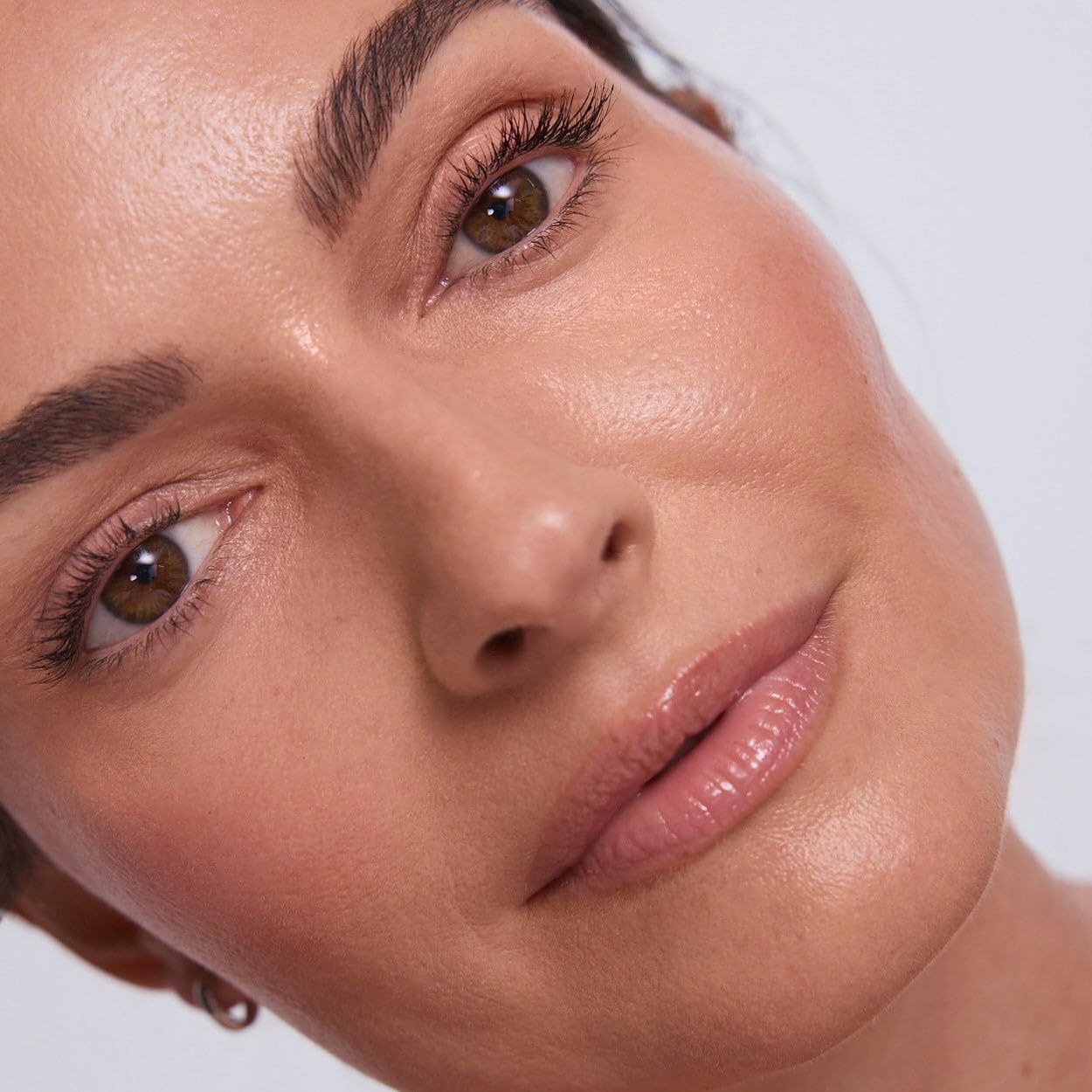 EarthsCure luminous highlighter stick capturing light for a dewy youthful glow