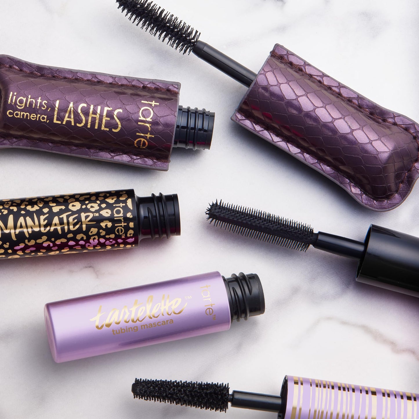 All three Tarte travel size mascaras arranged neatly next to their box packaging