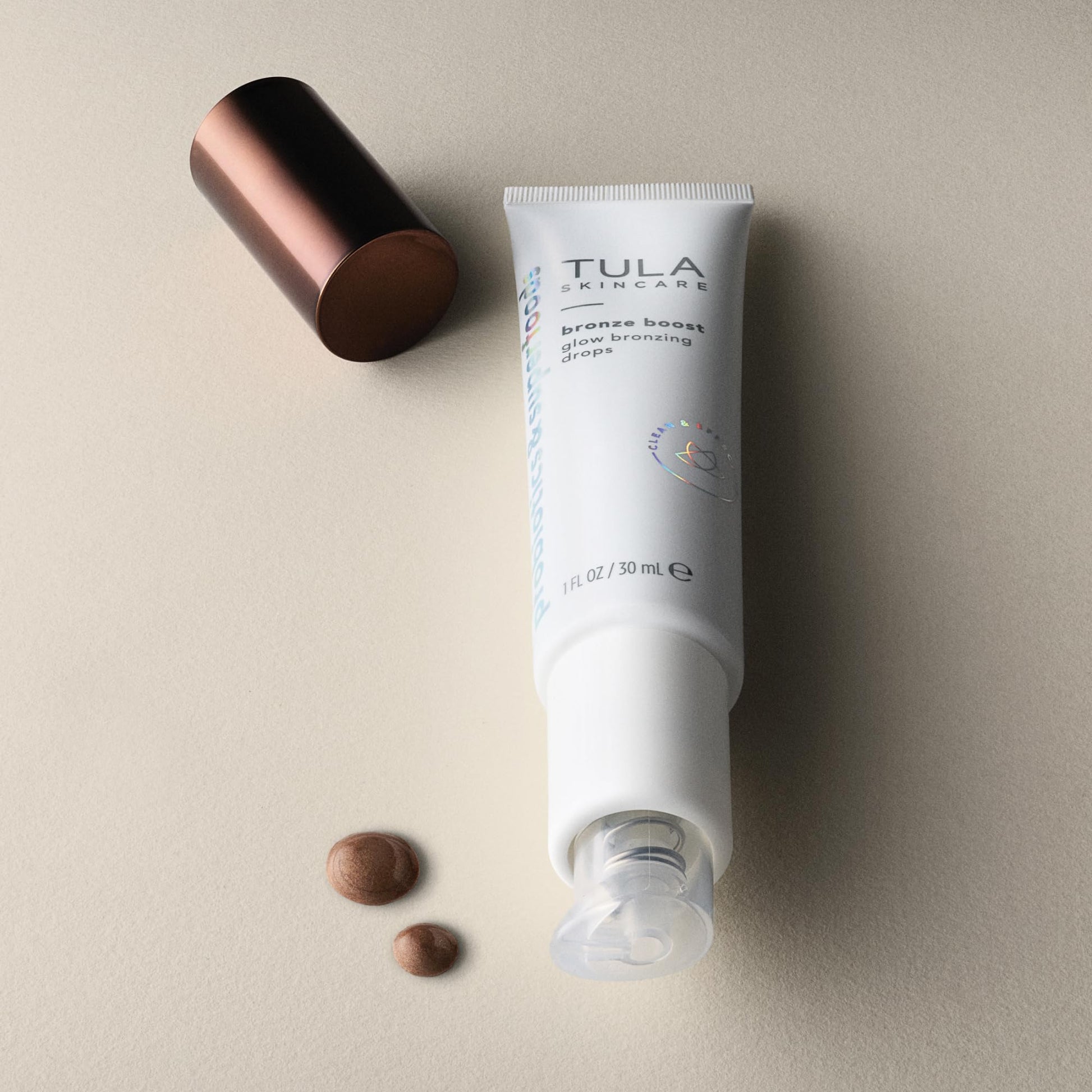 TULA bronze booster bottle standing next to its original retail box.