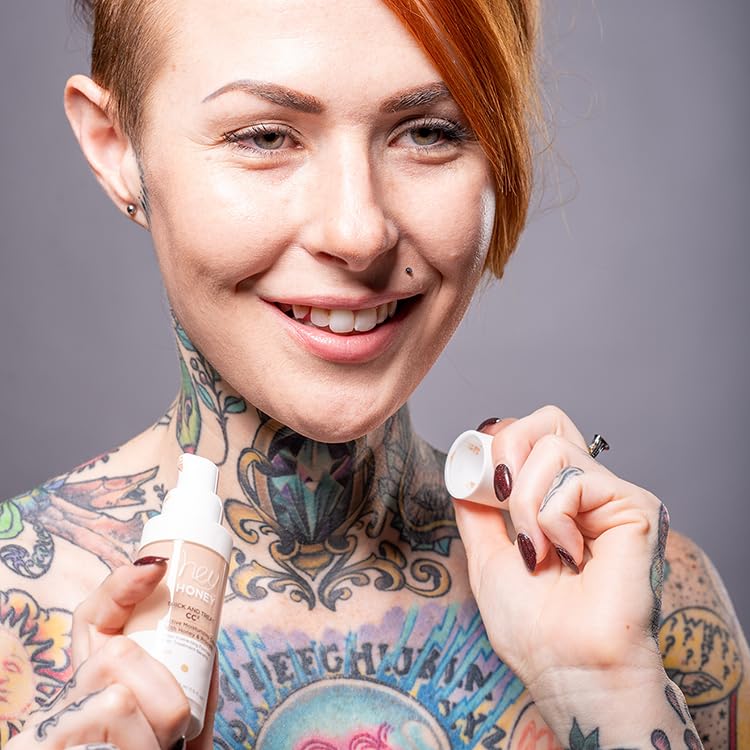 Model applying Hey Honey CC cream for skin coverage.