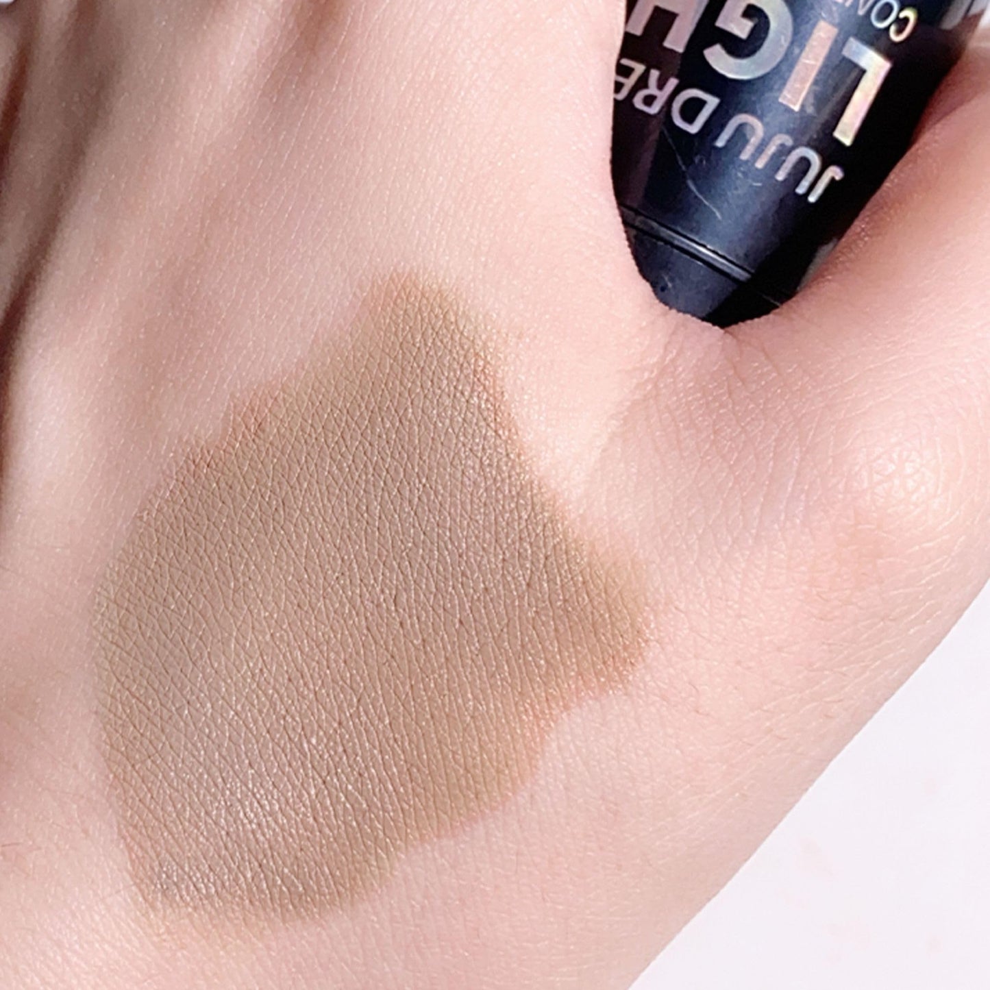 Lightweight buildable contour stick for fair skin being swatched on a surface.