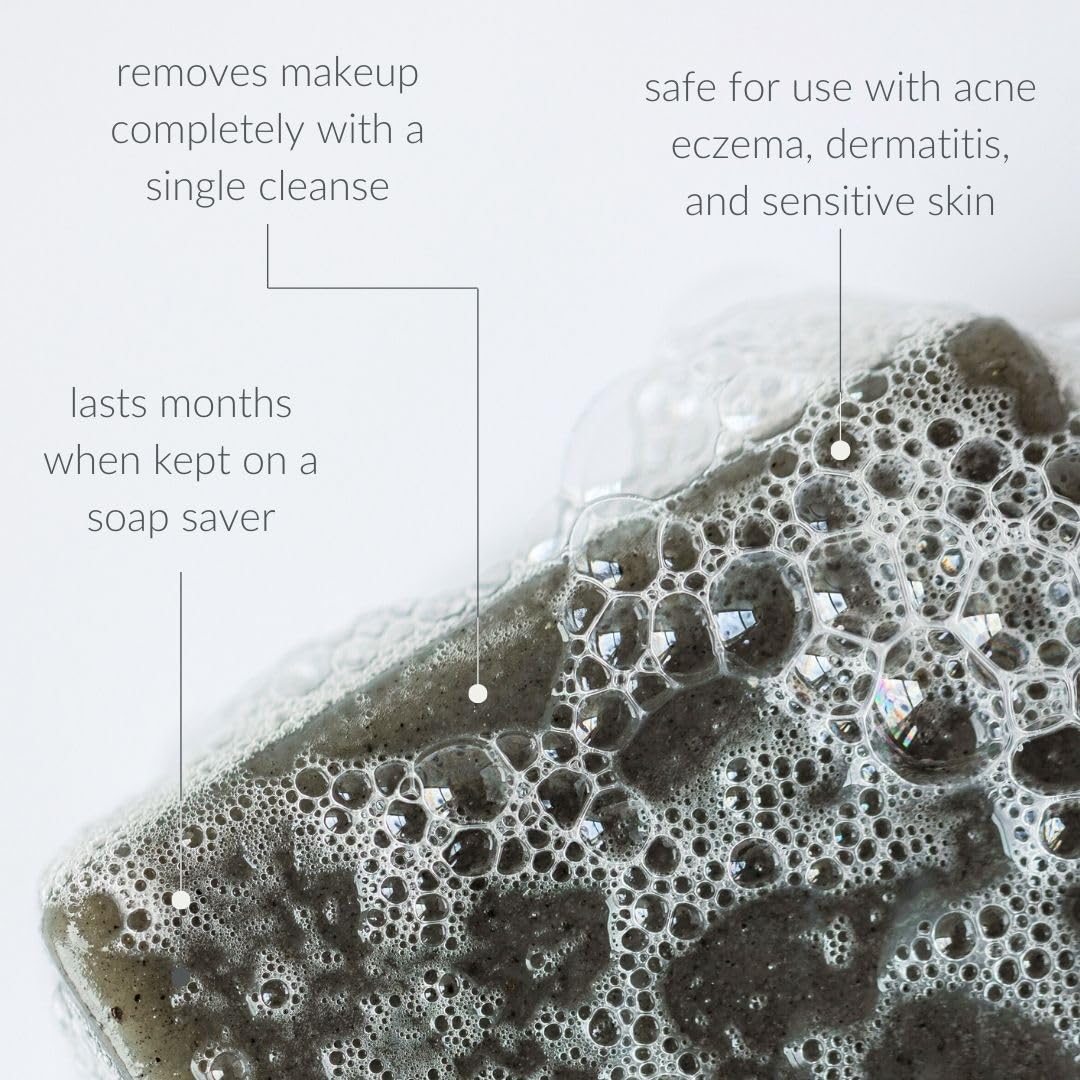 Osmia black clay soap bar next to natural ingredients