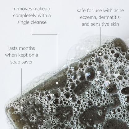 Osmia black clay soap bar next to natural ingredients