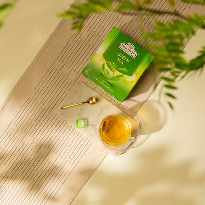 Steaming cup of green tea with Ahmad Tea box