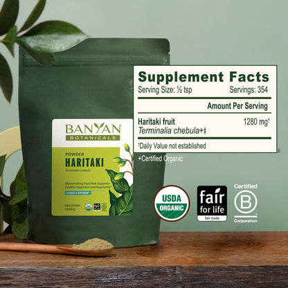 Banyan Botanicals Haritaki 1 pound bulk bag alongside warm water preparation for daily Ayurvedic routine.