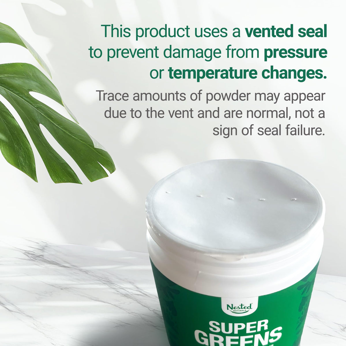 Scoop of green superfood powder next to the Nested Naturals container