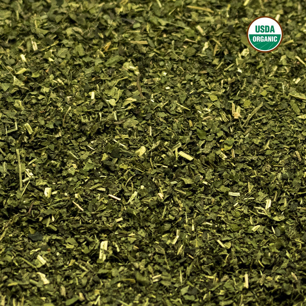 Brewed green herbal stinging nettle tea in a glass cup
