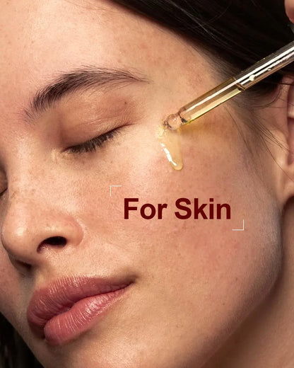 Pure organic rosehip seed oil being applied to the skin with a glass dropper
