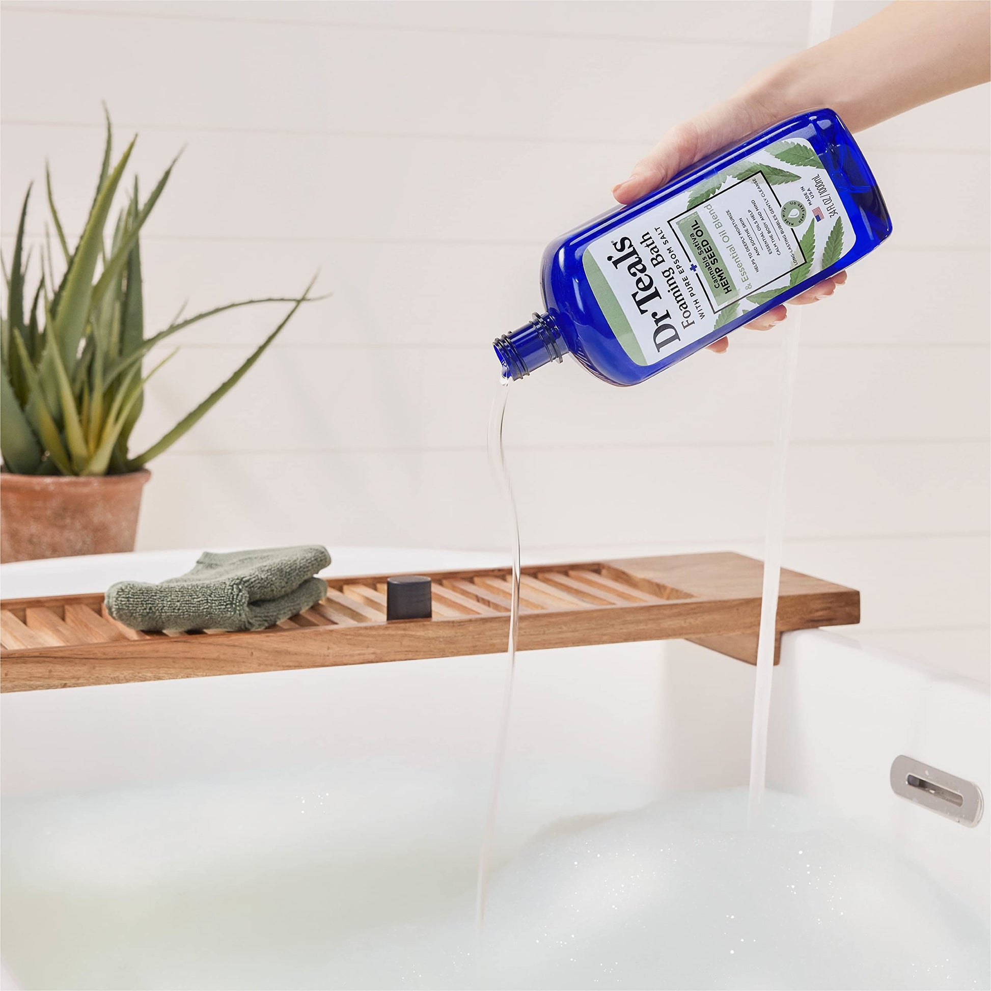 Pouring Dr Teal's cannabis sativa foaming bath under running water to create rich bubbles