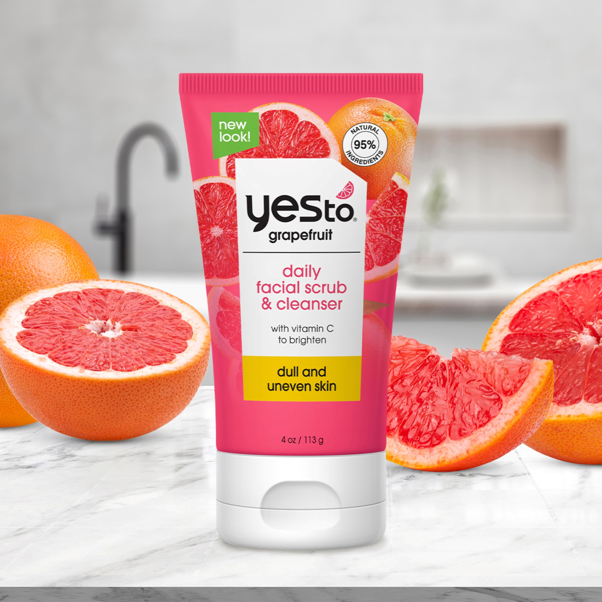 Yes To Grapefruit Daily Face Scrub tube standing upright beside fresh citrus lifestyle elements.