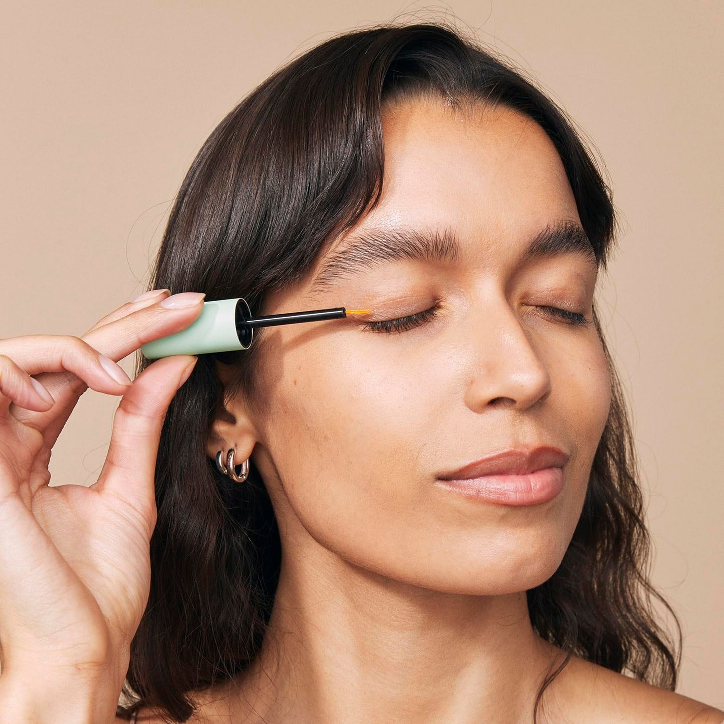 Premium clear eyelash serum bottle with applicator brush designed for easy daily precision line use