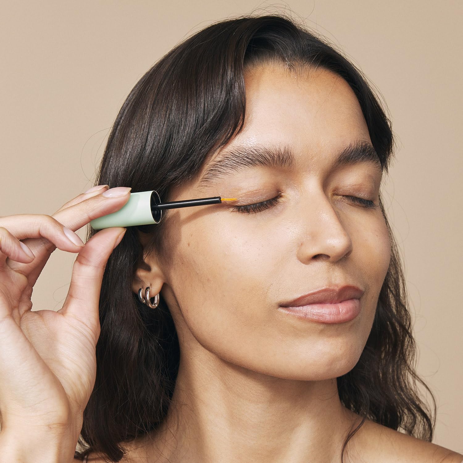 Premium clear eyelash serum bottle with applicator brush designed for easy daily precision line use