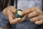 The Body Shop Mango Lip Butter 0.3 Ounce tin held in hand