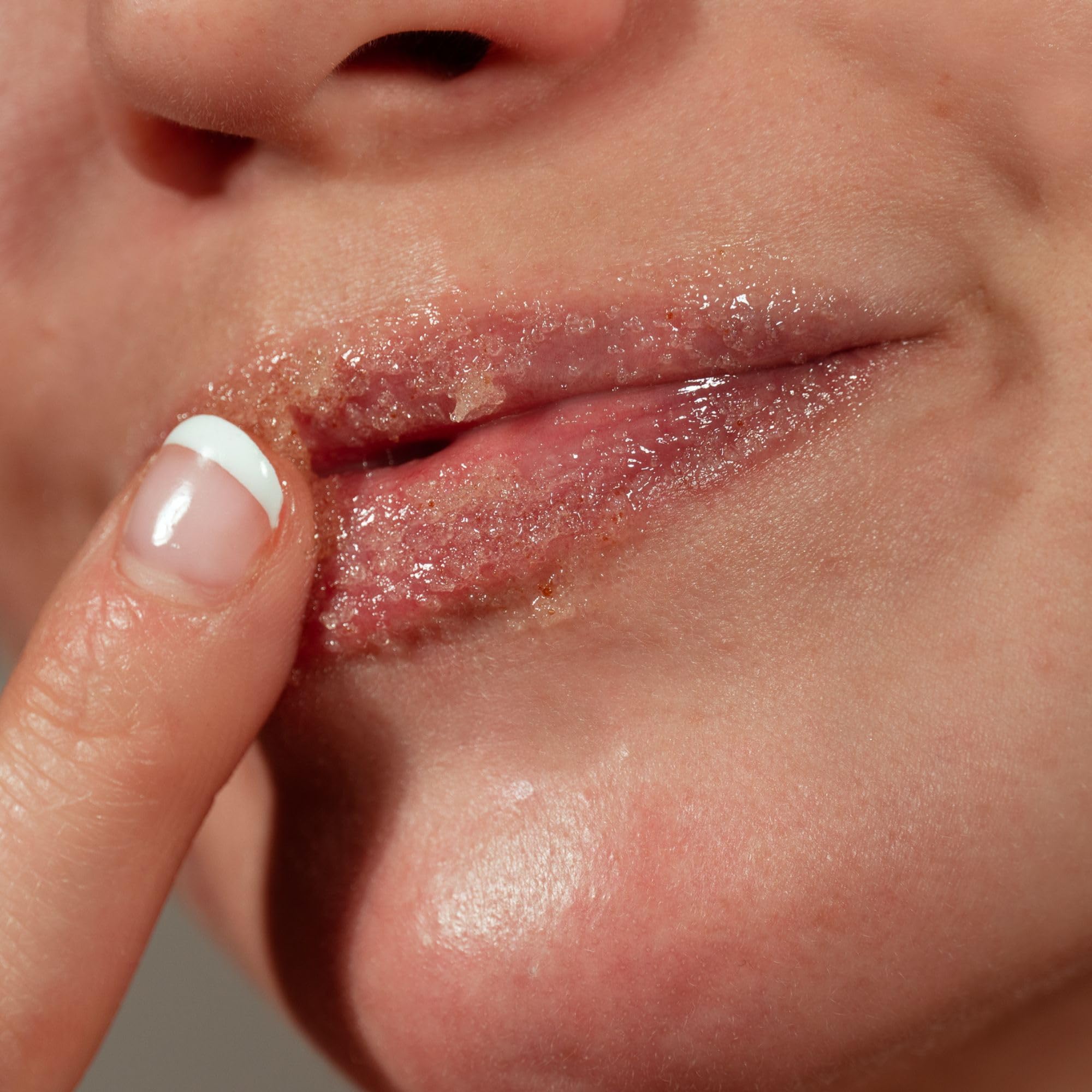 Application of brown sugar lip scrub on lips