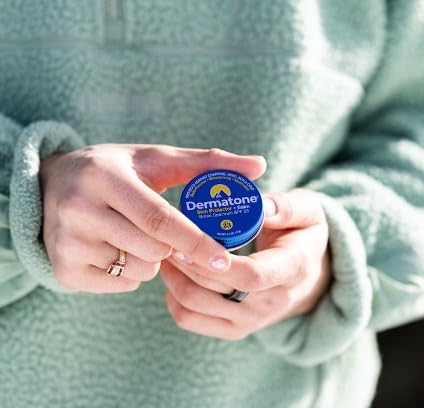 Dermatone SPF 23 tin held in hand for scale