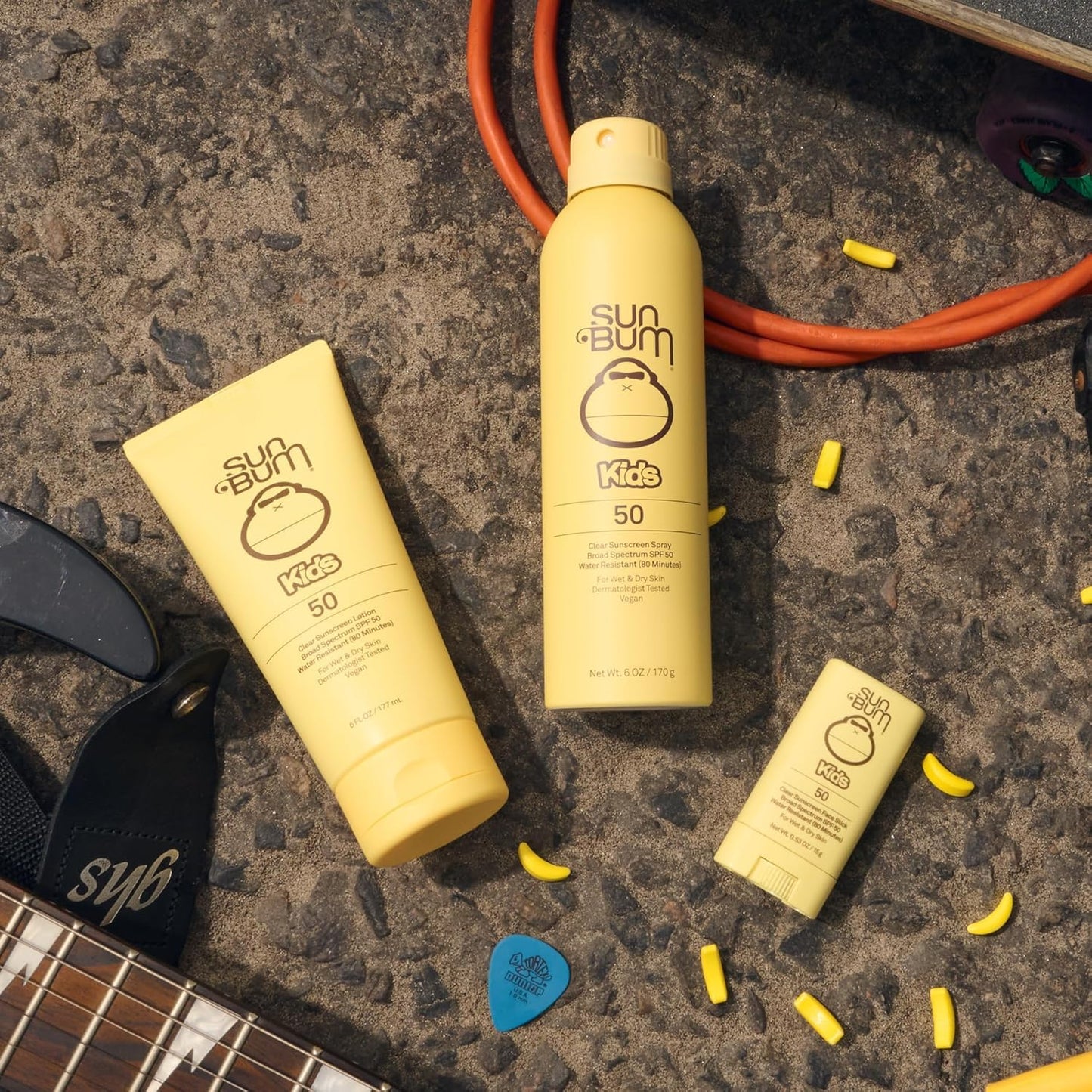 Sun Bum Kids SPF 50 spray bottle next to beach accessories