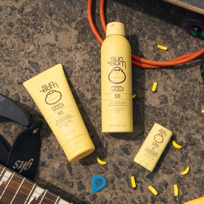 Sun Bum Kids SPF 50 spray bottle next to beach accessories