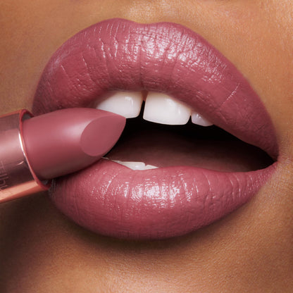 Close up view of the three travel size luxury lipsticks swatched on the back of a hand.
