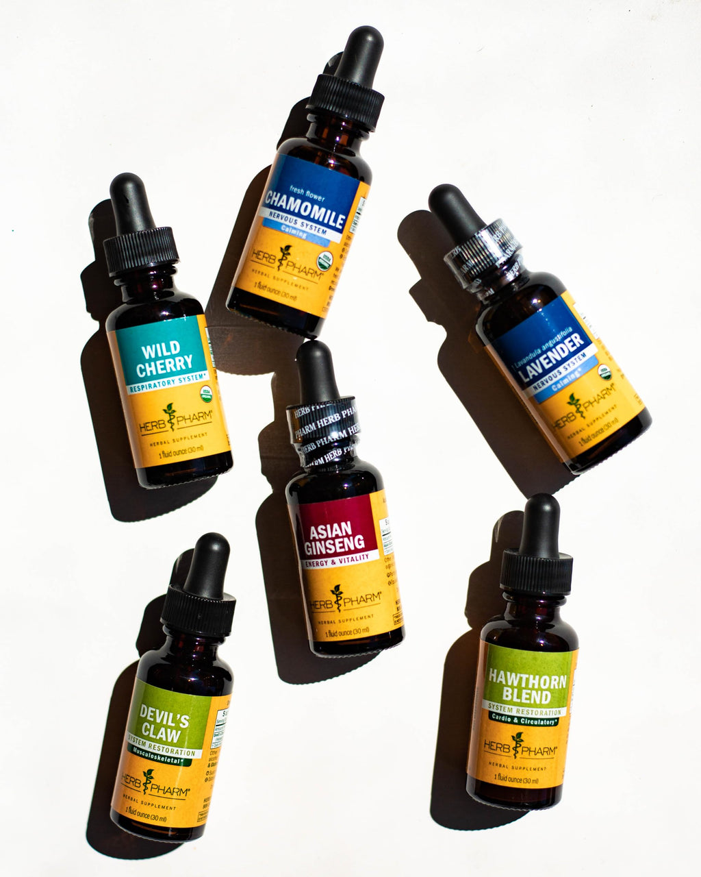 Full lifestyle view of Herb Pharm chamomile extract fluid ounce bottle next to a glass of water
