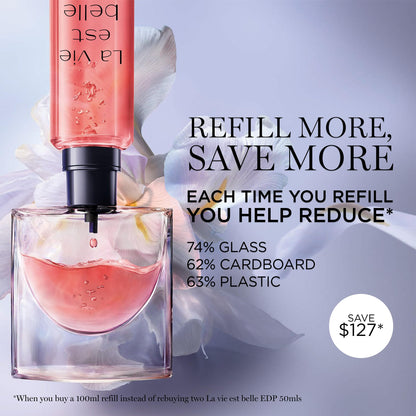 Lancôme La Vie Est Belle mini purse spray next to fresh pink flowers and vanilla pods