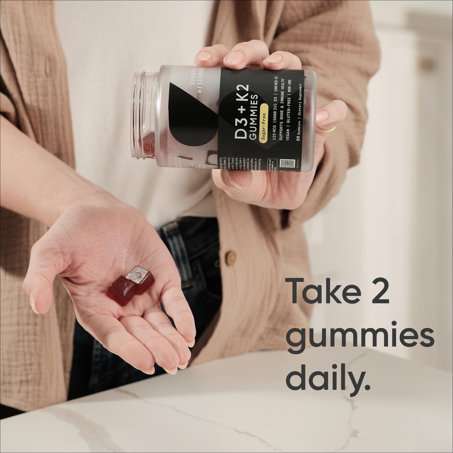 Sports Research D3 plus K2 cherry flavored gummies bottle showing vegan and non GMO seals.