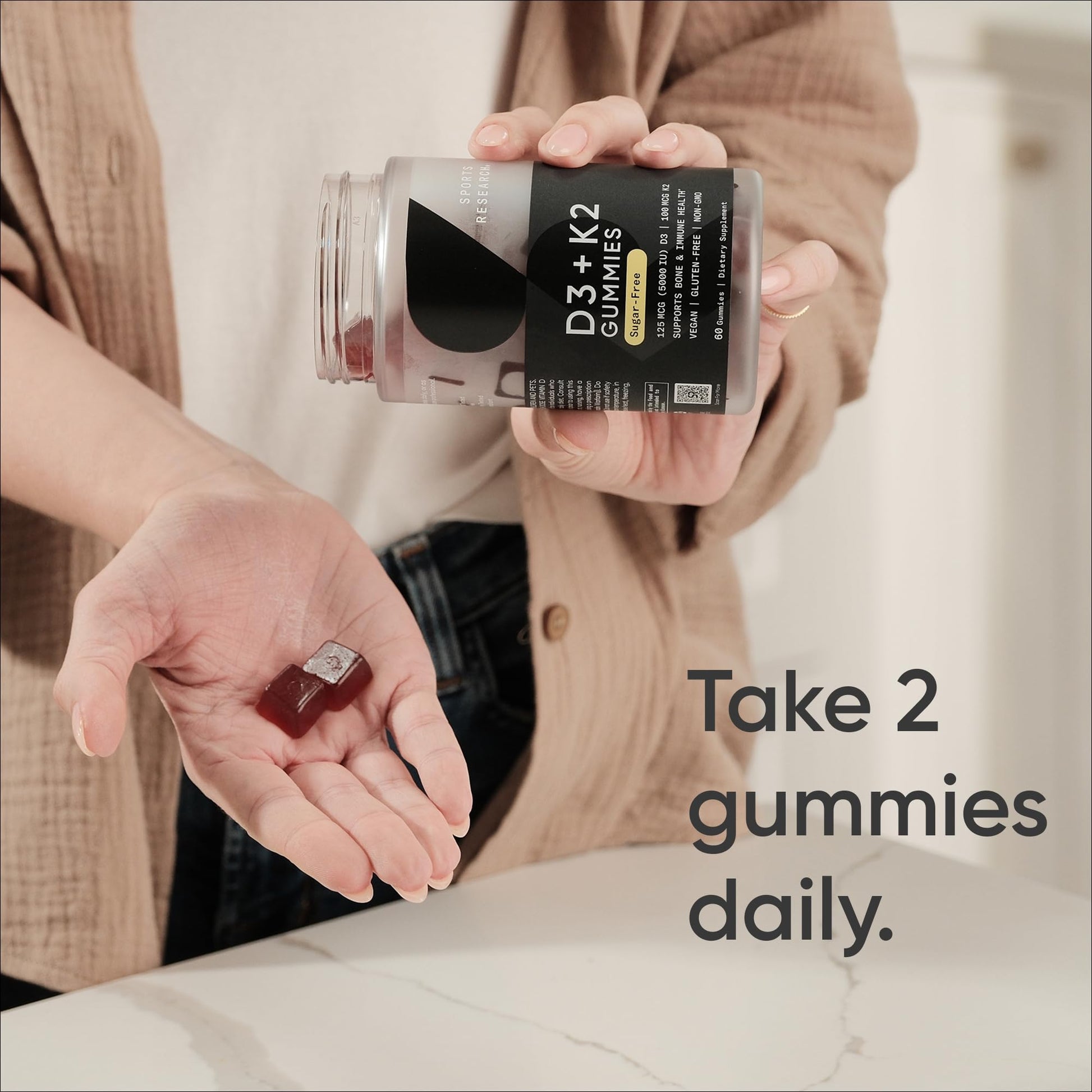 Sports Research D3 plus K2 cherry flavored gummies bottle showing vegan and non GMO seals.