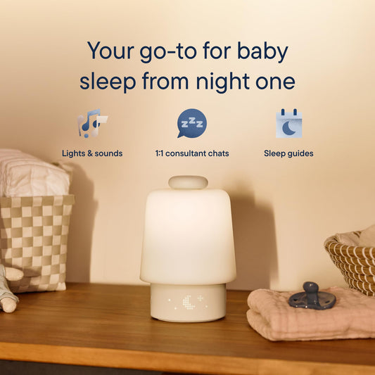 Hatch Baby white noise machine glowing with soft night light colors for baby bedtime routines.