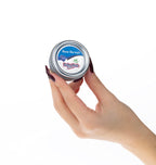 Nurse Harvey's baby rub being held to demonstrate the portable size of the tin.