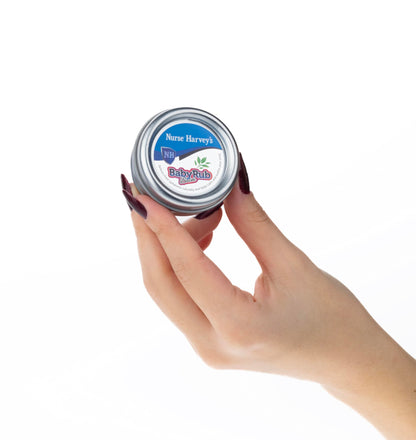 Nurse Harvey's baby rub being held to demonstrate the portable size of the tin.
