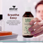 Liquid herbal cough syrup bottle placed on a clean background showing authentic USA import seal.