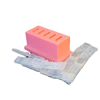 Pink 3D printed eye drop vial stand holding five disposable pipettes on a clean shelf