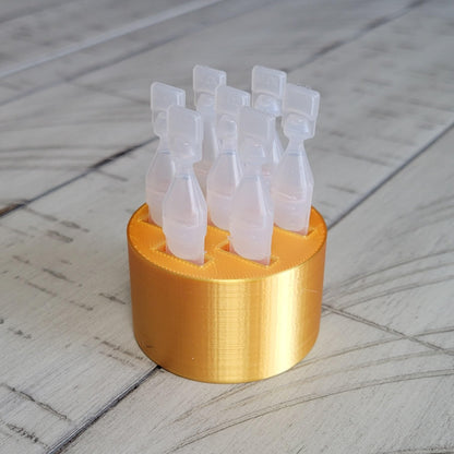 Compact star design eye drop container holder placed on a bedside table
