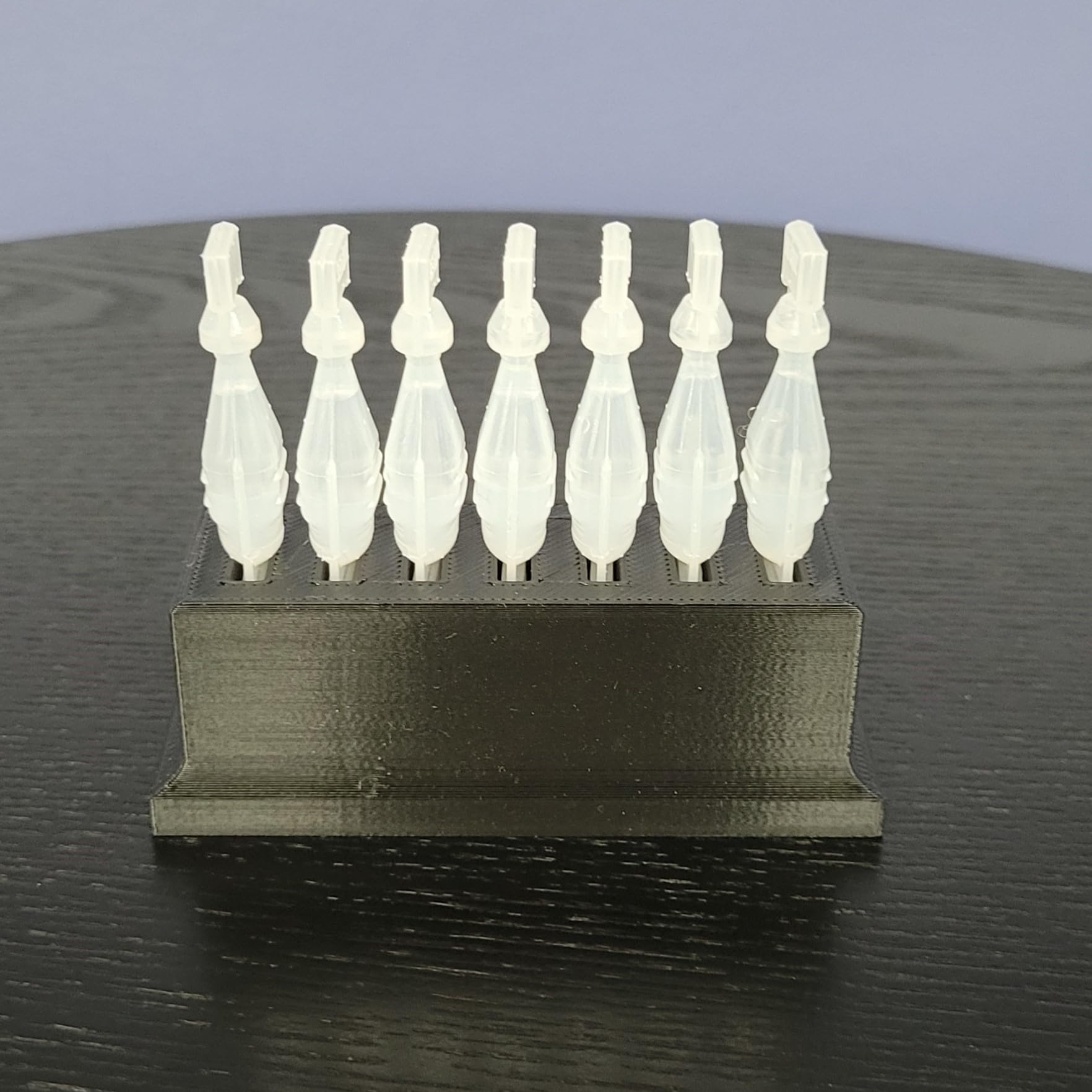 Side angle view of the 3D printed disposable eye drop container storage unit in matte black plastic.
