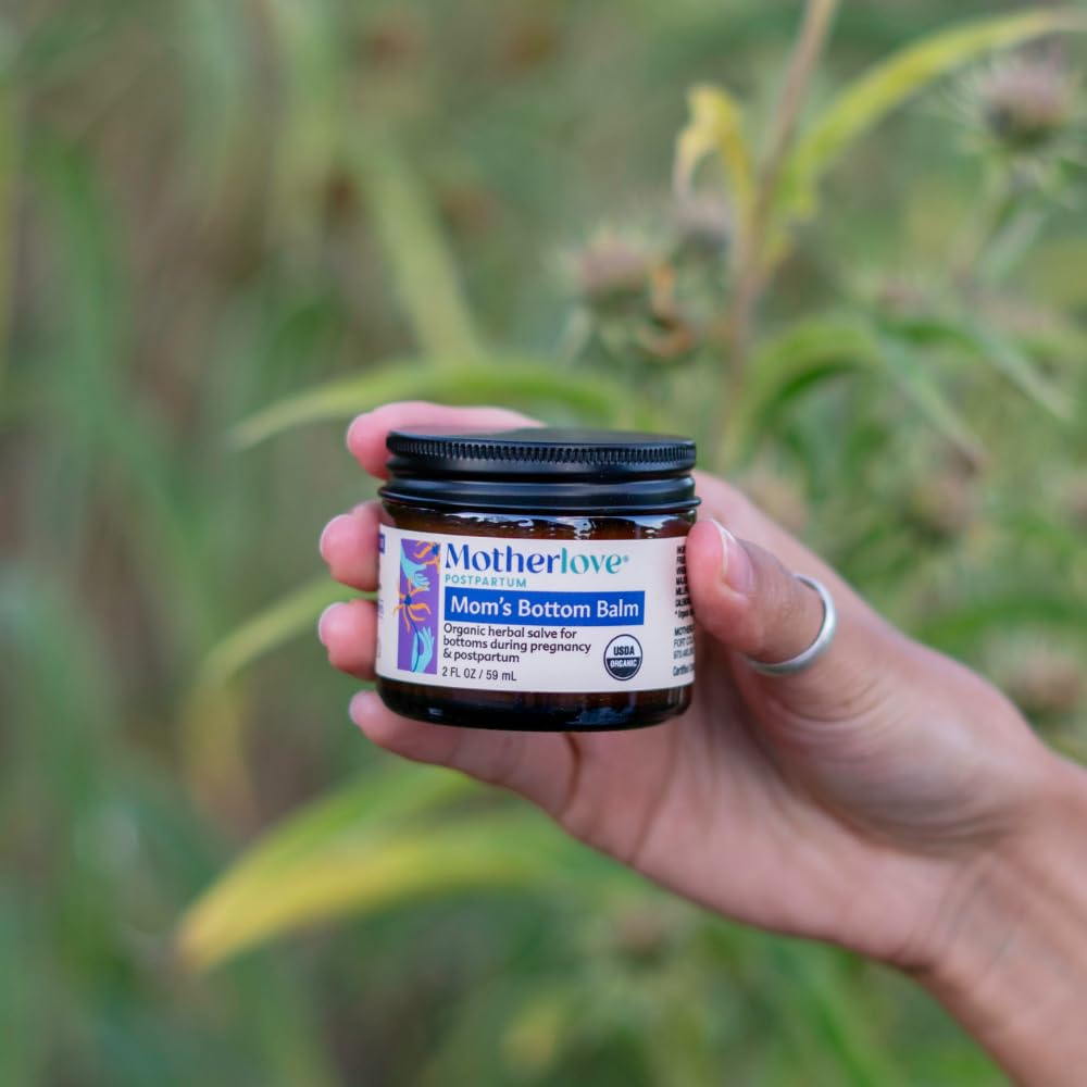 Motherlove Rhoid Balm organic ointment jar open to display the smooth natural herbal texture.
