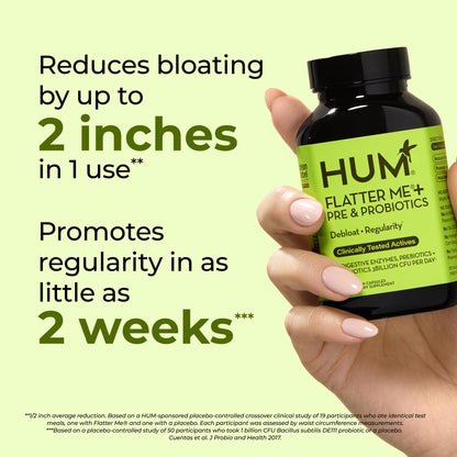 HUM Nutrition Flatter Me daily debloat capsules displayed alongside natural herbal ingredients like ginger and mint