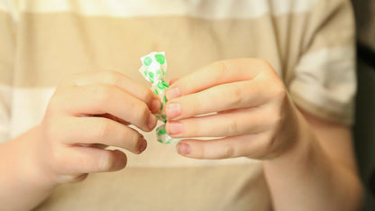 Close-up of a single wrapped Tummy Drops Peppermint lozenge highlighting travel-friendly convenience.