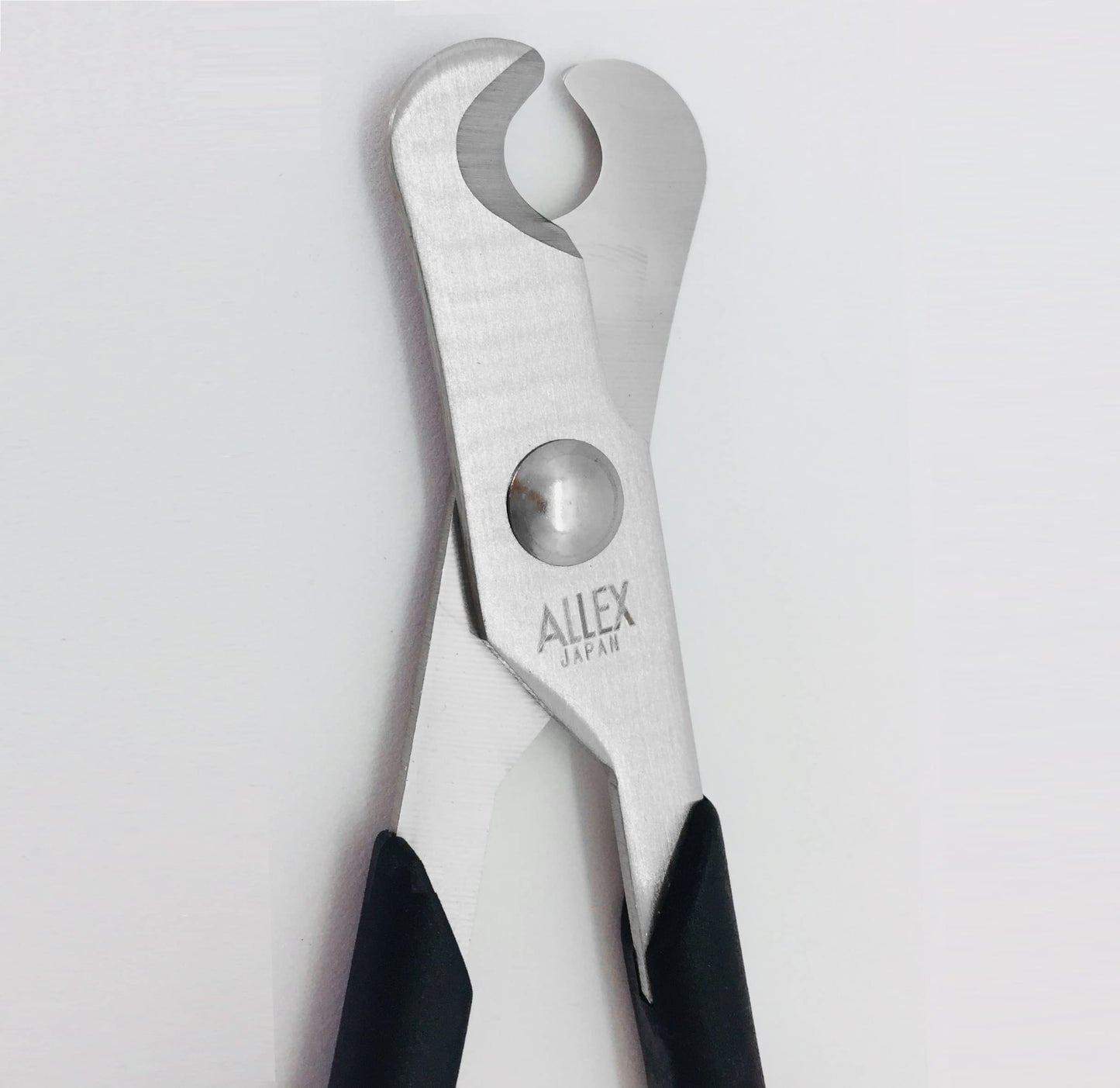 ALLEX small pill splitter scissors being held to demonstrate the ambidextrous handle design for caregivers.