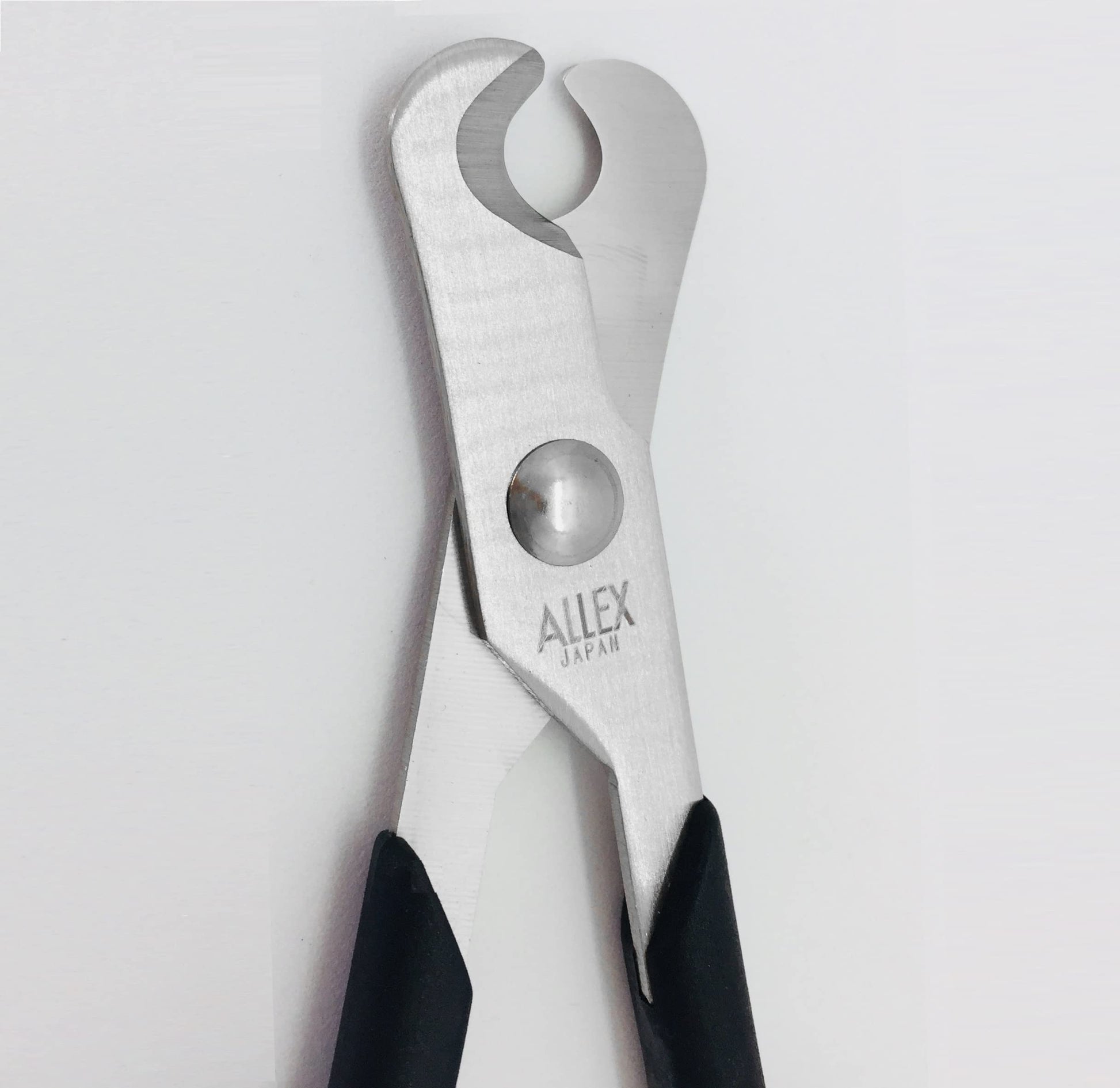 ALLEX small pill splitter scissors being held to demonstrate the ambidextrous handle design for caregivers.