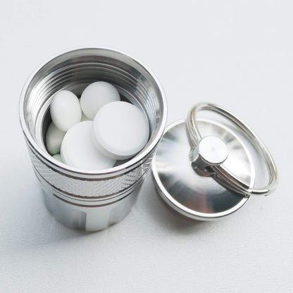 MEECN heavy duty travel medicine capsule being attached to a backpack using the included carabiner