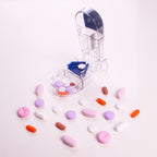 Compact medical pill splitter placed next to a travel pouch showing its portable size.