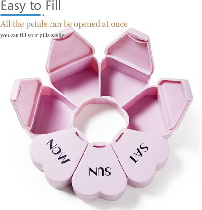 Compact heart shaped girly pill box held in hand to showcase portable size.