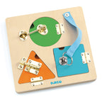Child hands playing with the metal key and latch on the Djeco wooden board