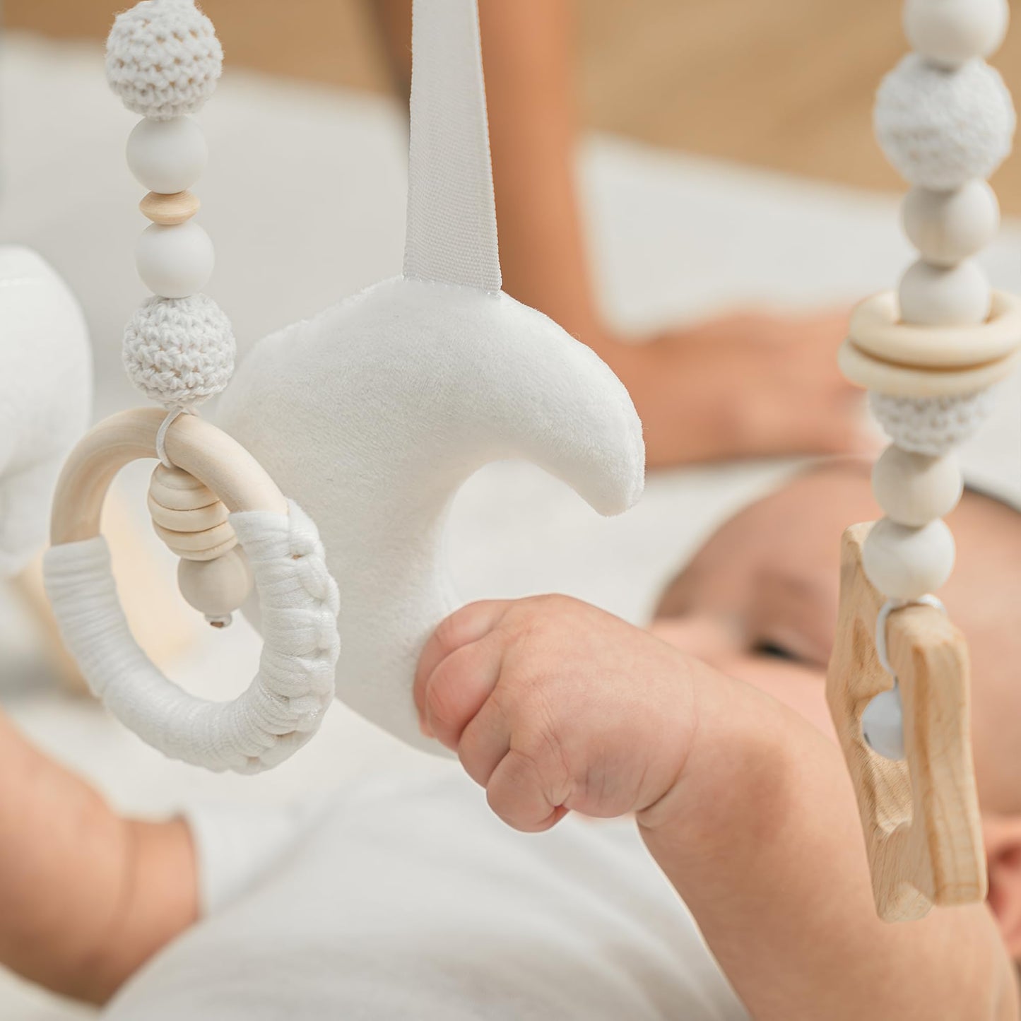 Baby interacting with Comfy Cubs wooden activity gym