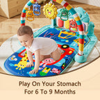 Infant lying on padded activity mat with hanging animal rattles