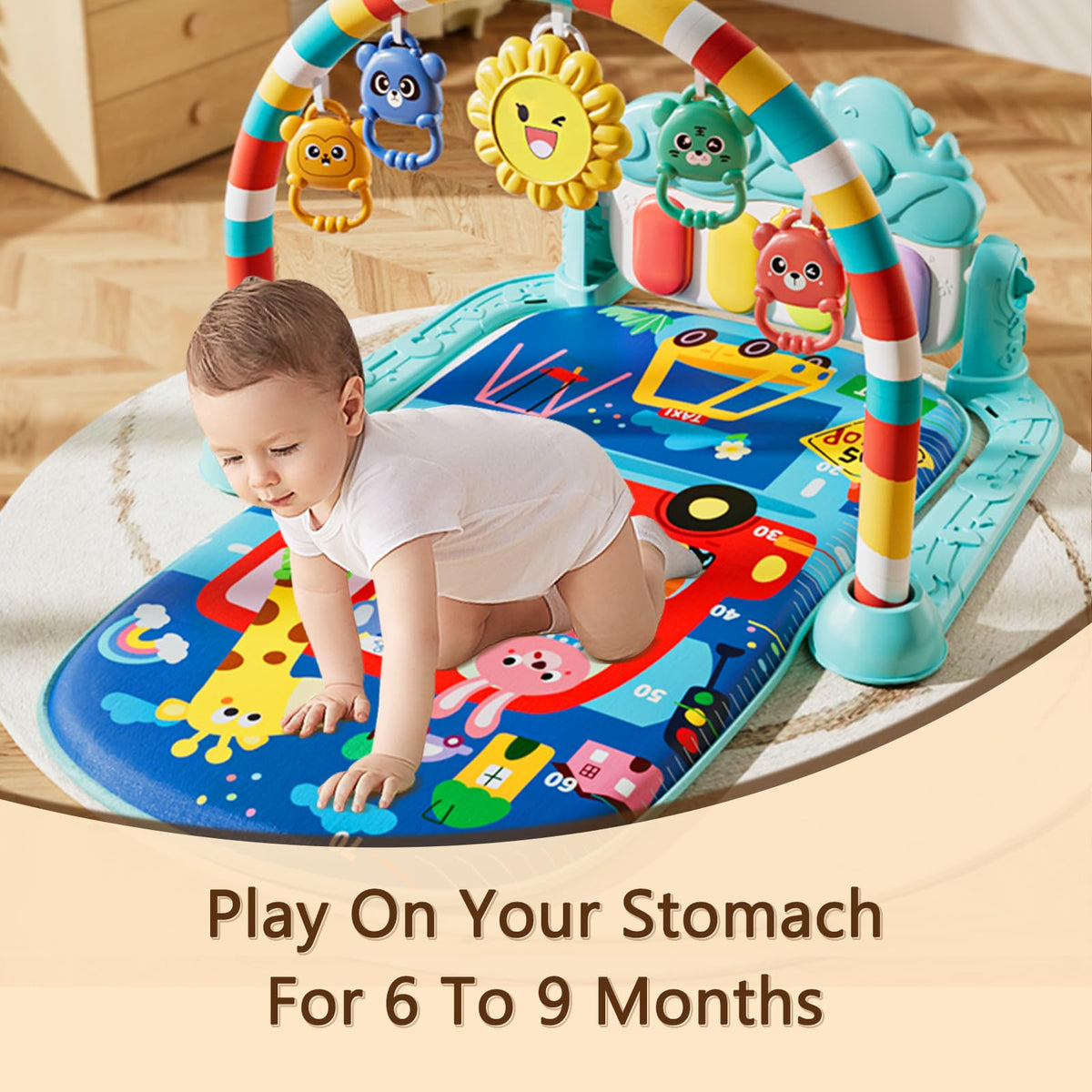 Infant lying on padded activity mat with hanging animal rattles