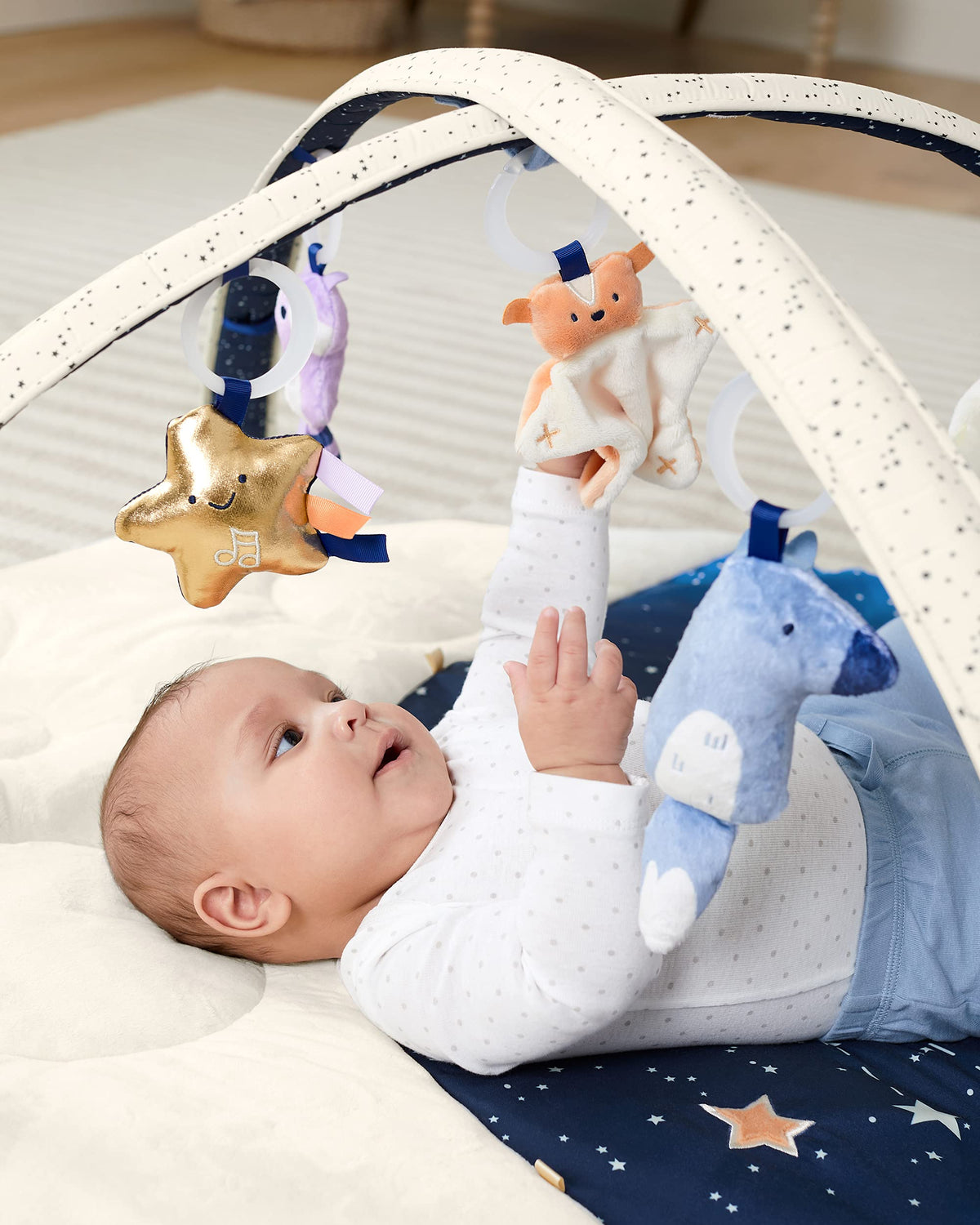 Skip Hop Activity Baby Play Gym showing the plush quilted mat and hanging sensory toys.