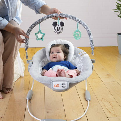 Infant sitting comfortably in the Winnie the Pooh bouncer seat